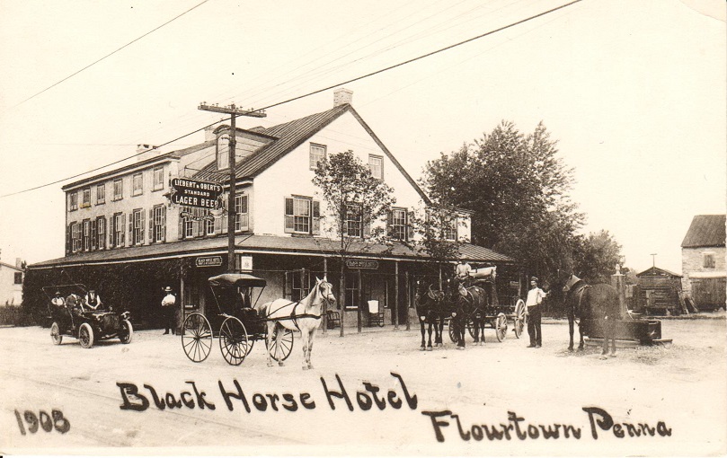 1908 Black Horse Hotel Flourtown, Penna. showing building with cars as well as horse and buggies in front.